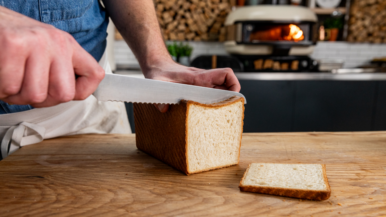 David Wright slicing a sandwich bread loaf in front of a Gozney Pizza Oven